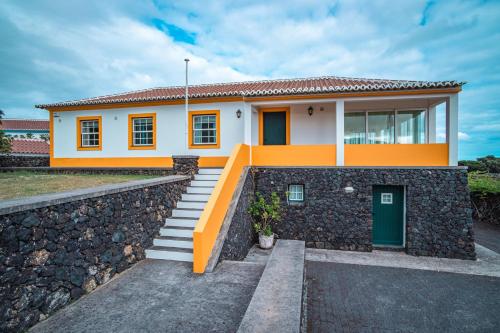a house with a stone retaining wall at Casa da Vinha in Biscoitos