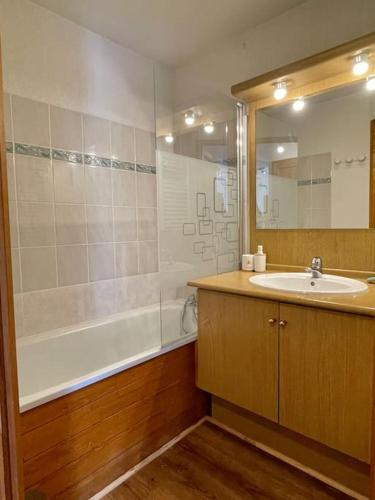 une salle de bain avec un lavabo, une baignoire et une douche dans l'établissement Appartement proche des pistes, à Praz-sur-Arly