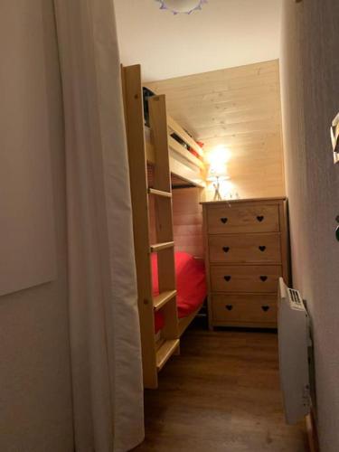 - une chambre avec des lits superposés et une commode dans l'établissement Appartement proche des pistes, à Praz-sur-Arly