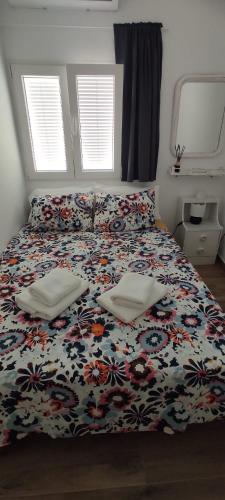 a bedroom with a bed with a floral bedspread at La Casita El Carmen in Quintanar de la Orden