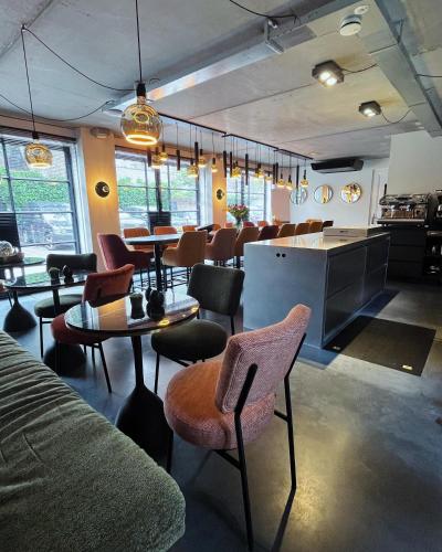 a room with chairs and tables and a bar at Boutique Hotel Nieuw Uilenburg in Den Bosch