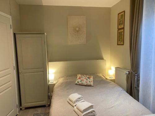 a small bedroom with a bed with towels on it at Hotel Saint Yves in Nantes