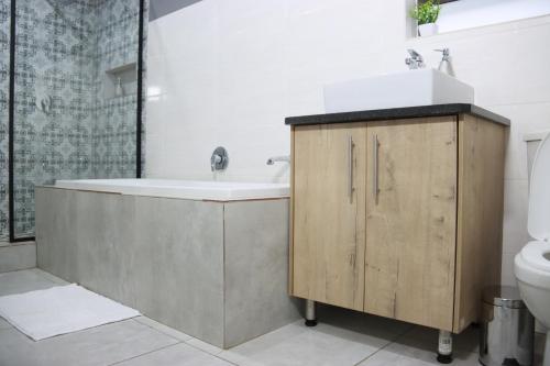 a bathroom with a sink and a tub and a toilet at Luxuryo in Zeerust