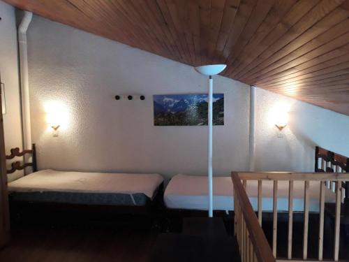 une chambre avec deux lits et un plafond en bois dans l'établissement Résidence Les Hameaux I - HAMEAUX 1 438 MAE-5151, à La Plagne Tarentaise