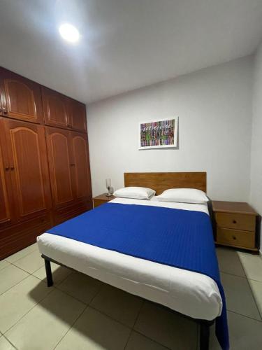 a bedroom with a large bed with a blue blanket at Katila-Rooms-Lima in Espargos