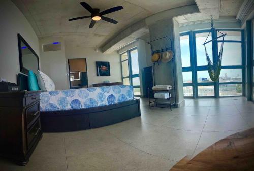 a living room with a couch and a ceiling fan at Spacious Loft-sea View By Stay Here Pr in San Juan
