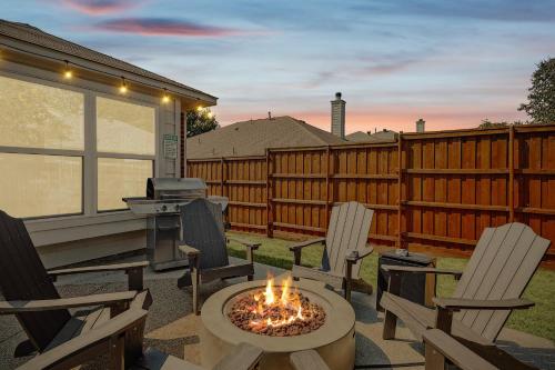 a patio with chairs and a table with a fire pit at 4BD 2BA Saginaw Sanctuary - Pool Firepit Laundry in Saginaw