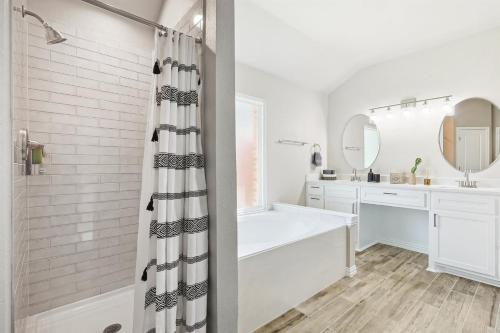 een witte badkamer met een bad en een wastafel bij 4BD 2BA Saginaw Sanctuary - Pool Firepit Laundry in Saginaw