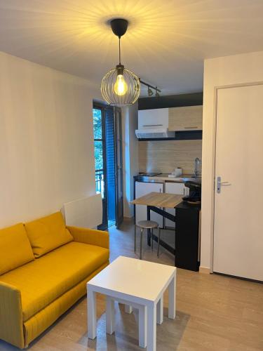 un salon avec un canapé et une table dans l'établissement Résidence HORME, à Vichy