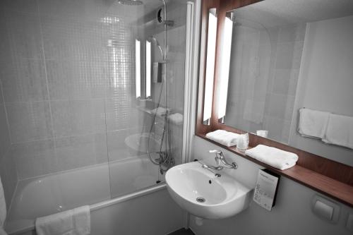 a bathroom with a sink and a mirror and a shower at Campanile Vichy - Bellerive in Bellerive-sur-Allier