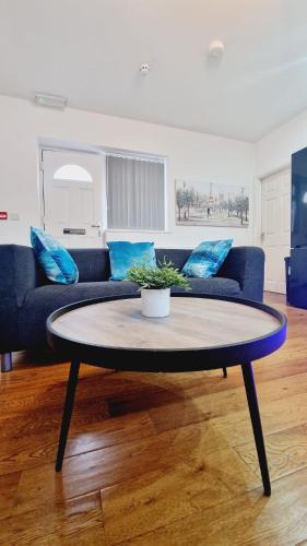 a living room with a blue couch and a coffee table at Leeds Kelso in Leeds