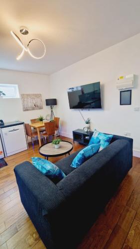 a living room with a blue couch and a tv at Leeds Kelso in Leeds