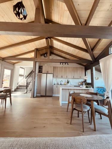a kitchen and dining room with a table and a refrigerator at REY Chalet in Vatra Dornei