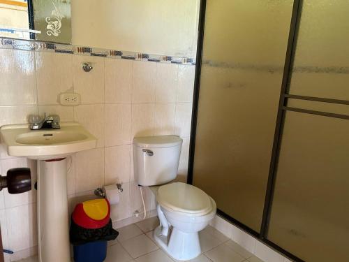 a bathroom with a toilet and a sink and a shower at Hotel campestre manantial del Quindio in Montenegro