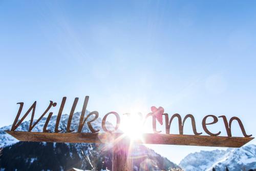 a woman standing on top of a mountain with a sign that reads wintergan at Gästehaus Fritz in Mittelberg