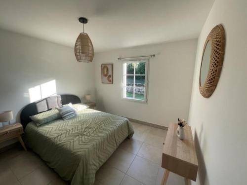 a bedroom with a bed and a wooden table at Charmante maison neuve in Saint-Gelais