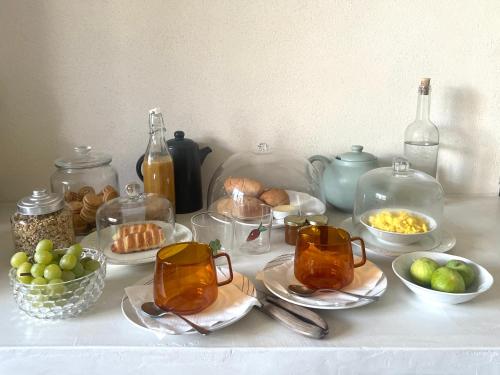 een tafel met kopjes, borden en kommen met eten bij Il Castello in Seneghe