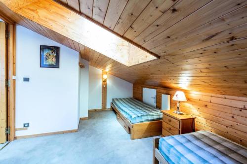 deux lits dans une chambre aux murs en bois dans l'établissement Résidence Plattieres - PLATTIERES 38 MAE-4111, à Les Allues