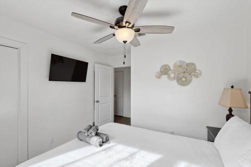 a white bedroom with a ceiling fan and a bed at 4-BD 2-BA Home Retreat Laundry Backyard in Weatherford