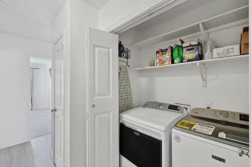 a small kitchen with a stove and a washer at 4-BD 2-BA Home Retreat Laundry Backyard in Weatherford
