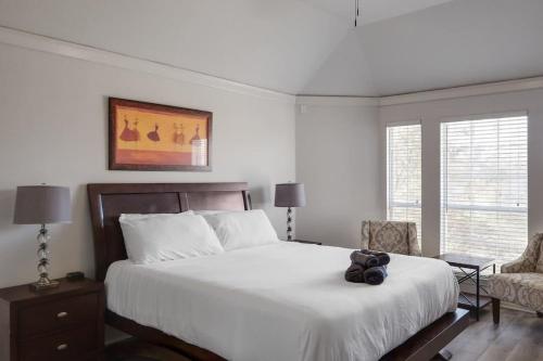 Un dormitorio con una cama con un osito de peluche encima. en Dream Vacay in Central Plano - Pool & Grill, en Plano