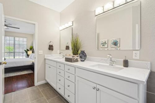 une salle de bain blanche avec un lavabo et un miroir dans l'établissement 5BD Vacation Retreat - Pool Patio Cinema, à Lake Dallas