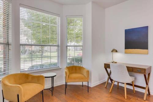 a room with a desk and chairs and windows at Luxury Mansion Paradise - Cinema Room, Pool, Spa in Rowlett