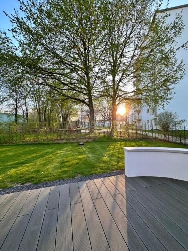 a wooden deck with a bench in front of a yard at Stadtwohnung mit Garten in Kassel