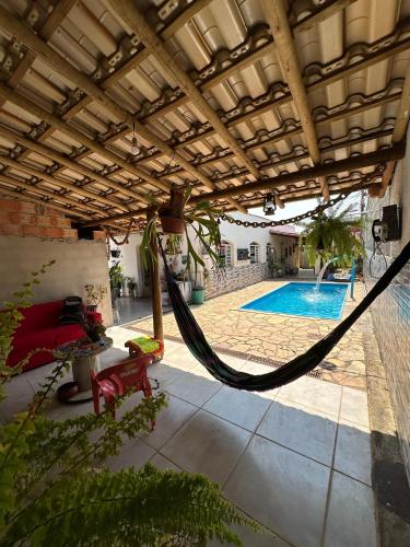 a patio with a hammock and a swimming pool at Hostel Aconchego in Brumadinho