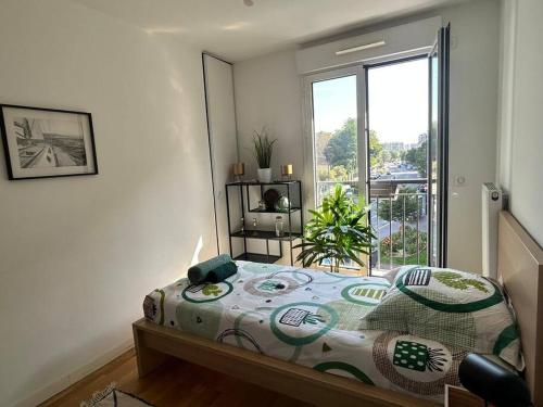 a bedroom with a bed and a large window at Le Timbaud, T4 cosy, balcon, parking, aux portes de Paris in Drancy
