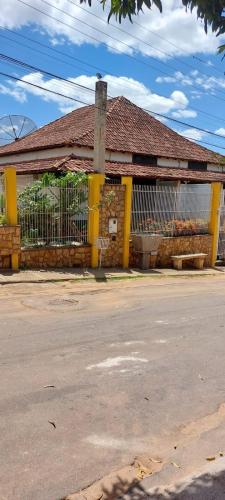 an old building with a fence in front of a street at Pousada Colonial in Cachoeiro de Itapemirim