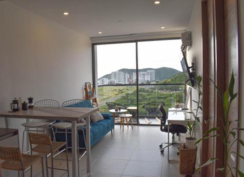 a living room with a table and chairs and a large window at Apartamento frente al mar en Santa Marta in Santa Marta