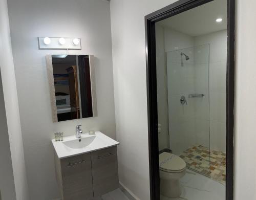 a bathroom with a toilet and a sink and a shower at Arecibo Inn in Arecibo