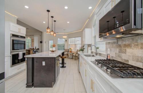 a kitchen with white cabinets and a stove top oven at Big Texas Living - Spacious 5-BD with Pool in Cypress