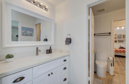 a white bathroom with a sink and a mirror at Big Texas Living - Spacious 5-BD with Pool in Cypress
