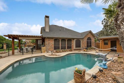 a swimming pool in front of a house at Stunning 6BR Pool - Great for Big Groups in Rowlett