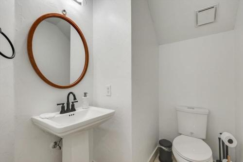 a white bathroom with a sink and a mirror at Stunning 6BR Pool - Great for Big Groups in Rowlett