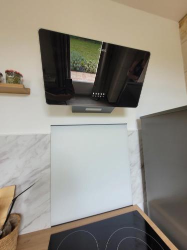 Lugon et l’Ile du CarneyにあるGîte Piscine SPA proche Bordeauxの白い壁の上に薄型テレビが備わります。