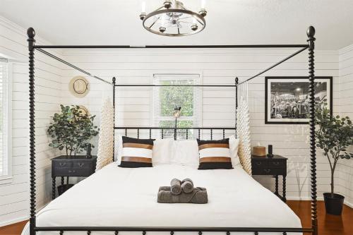 a bedroom with a black canopy bed with two towels on it at 3BD Farmhouse Country Living - Pool Patio Firepit in McKinney