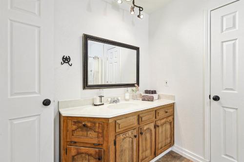 a bathroom with a sink and a mirror at 3BD Farmhouse Country Living - Pool Patio Firepit in McKinney