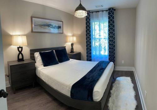 a bedroom with a large bed with blue pillows at Charming Gainesville Townhome 3 in Gainesville