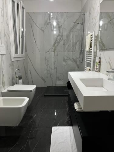 a white bathroom with two sinks and a toilet at Appartamento Piero in Calenzano