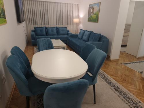 a living room with a couch and a table and chairs at Turquoise Apartment in Novi Pazar