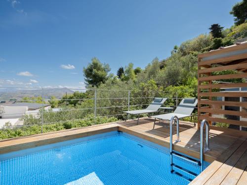 a swimming pool with two chairs next to at Villa Moon Total Relax in Alcamo