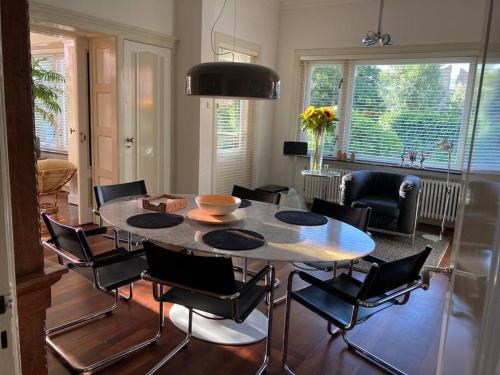 a living room with a dining room table and chairs at Villa Bollenstreek in Hillegom