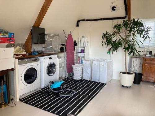 a laundry room with a washing machine and a snowboard at Villa Bollenstreek in Hillegom