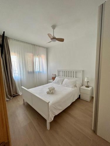 a bedroom with a white bed with a stuffed animal on it at Casa La Cañada in San Sebastián de la Gomera