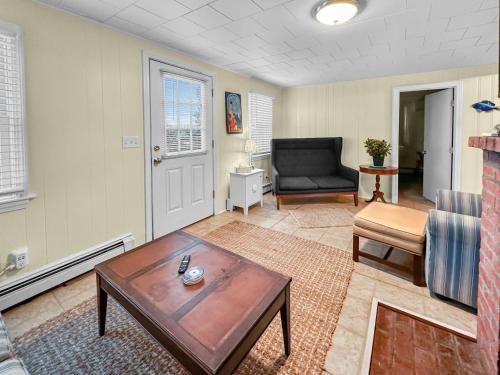 a living room with a table and a chair at 183 #2 North Shore Boulevard Cape Cod - 50 Steps in East Sandwich