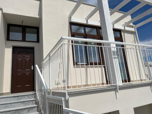 a white house with a wooden door and stairs at RussoHome in Monte di Procida