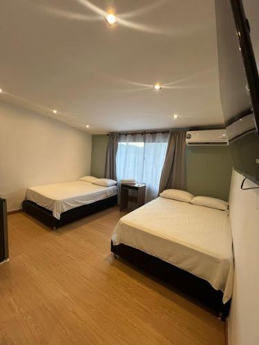 a bedroom with two beds and a window at Loft Recuerdos de mi tierra in Medellín